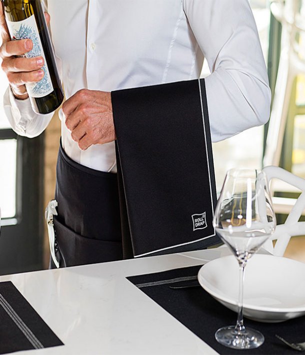 <img src=Πετσετόπανο Elegance Μαύρο Ρολό 10 τεμ alt=Άνδρας με λευκό πουκάμισο και μαύρη πετσέτα σερβίρει κρασί> 