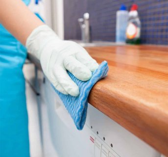 <img src=Γάντια Latex Μιας Χρήσης Κουτί 10 τεμ Jana=Γυναίκα φοράει γάντια και καθαρίζει τον καφέ πάγκο της κουζίνας>